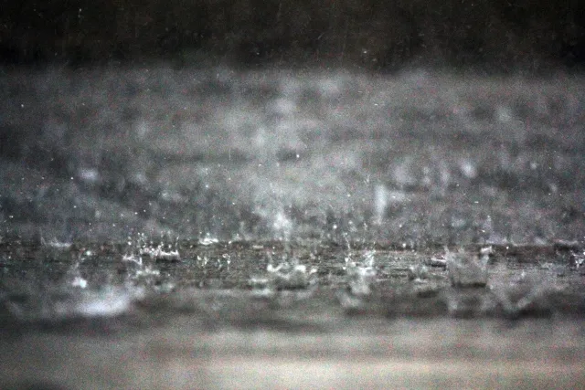 短時間の土砂降りで雨樋へ一気に雨水が流れ込むゲリラ豪雨のイメージ